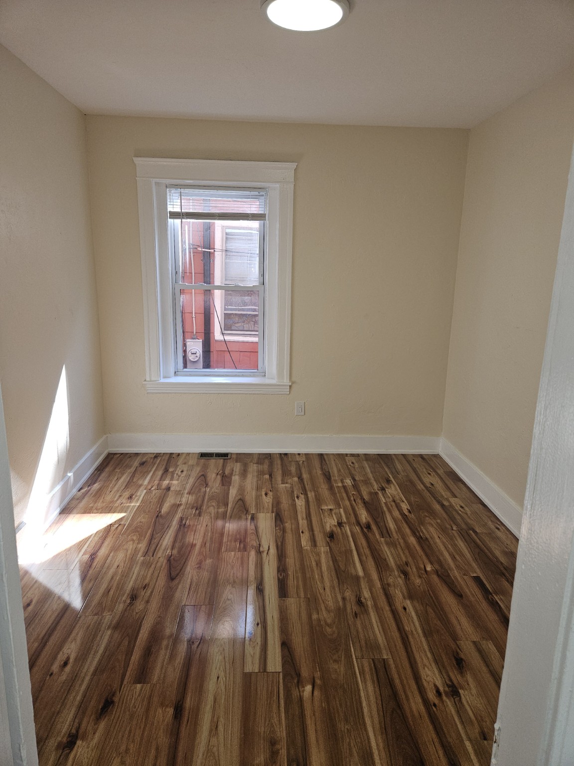 Bedroom with warm wood flooring at 30 Thorne Street, Apartment 1
